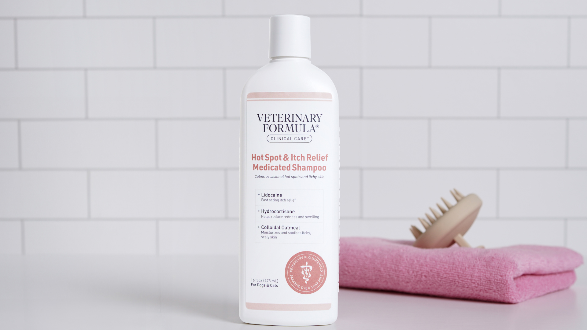 A person holding a bottle of veterinary medicated dog shampoo next to cotton pads and a towel on a bathroom counter